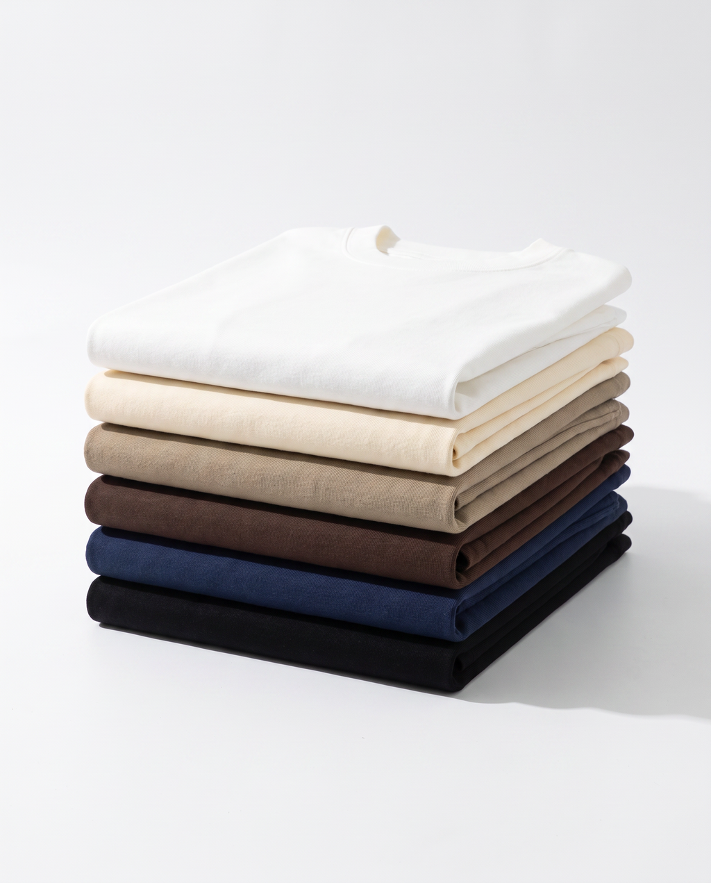 The Everyday Tee, all six colours folded in a stack