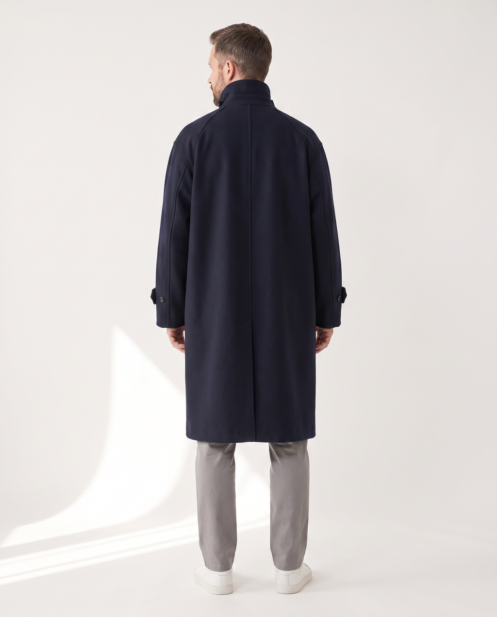 The Coat in navy, back view with the collar worn up