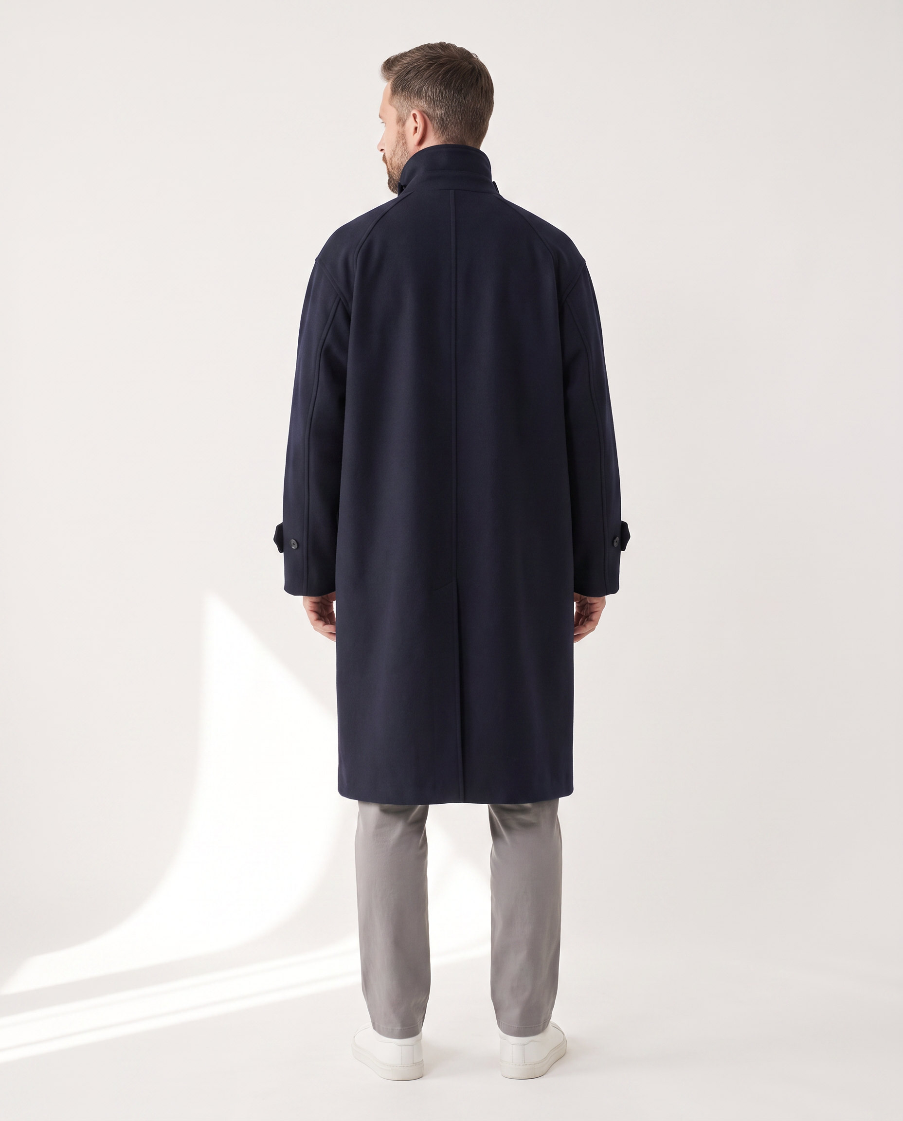 The Coat in navy, back view with the collar worn up